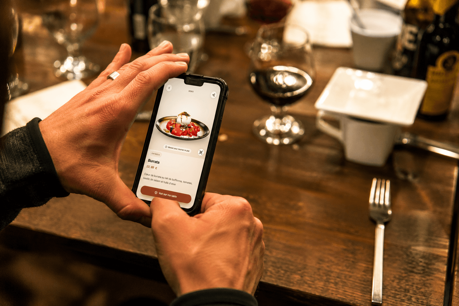Un client photographie son plat au restaurant avec son smartphone