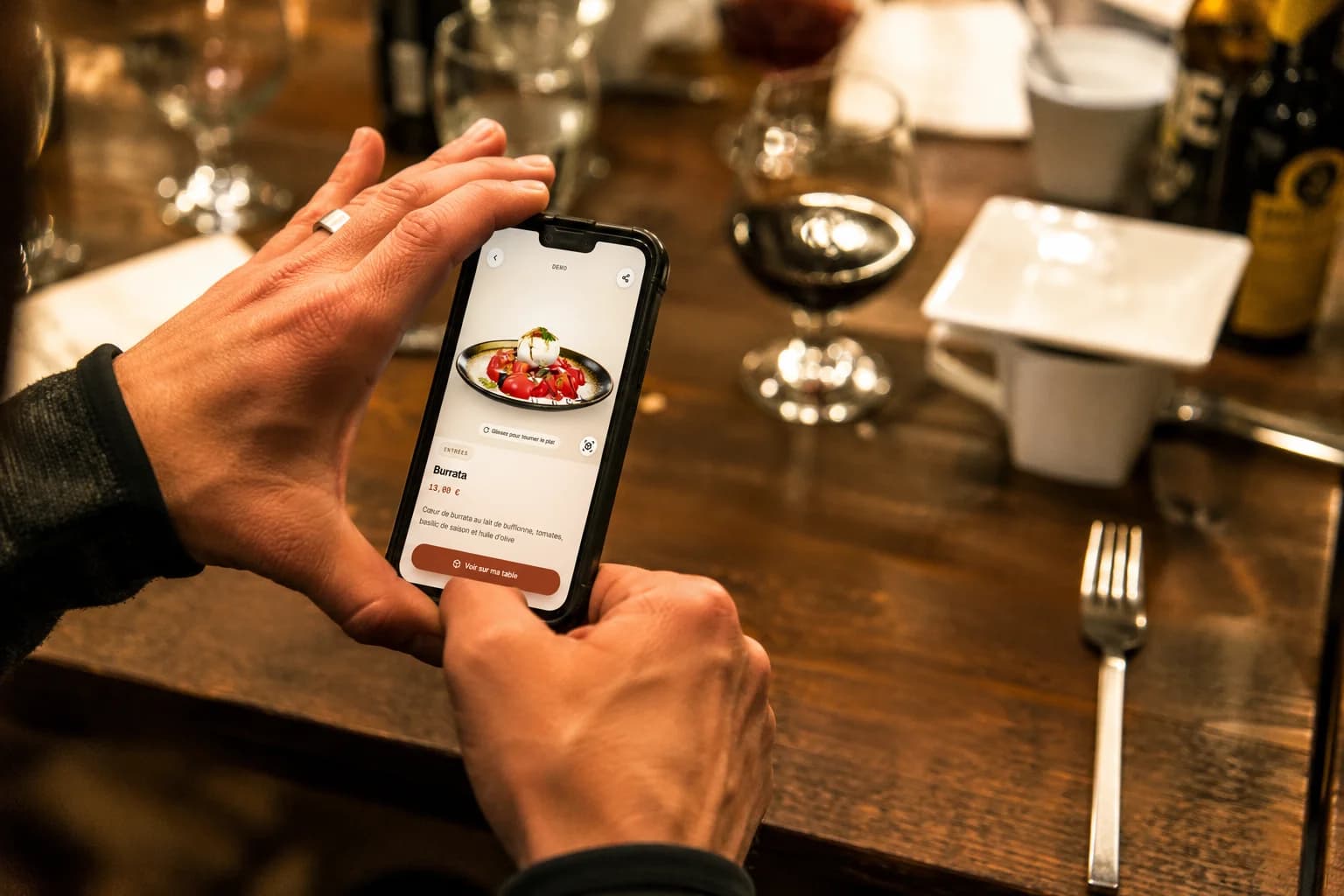 Un client photographie son plat au restaurant avec son smartphone